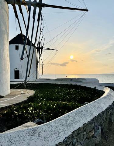 Windmill at sunset with a view of the ocean.