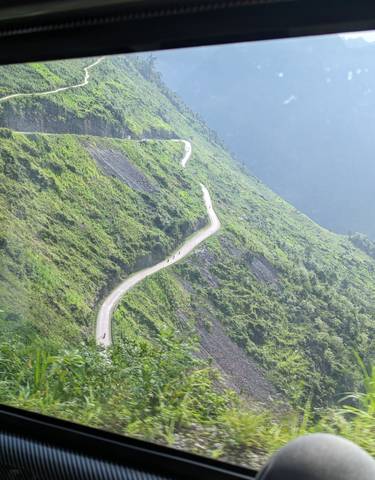Snaking road on a lush green mountain side.