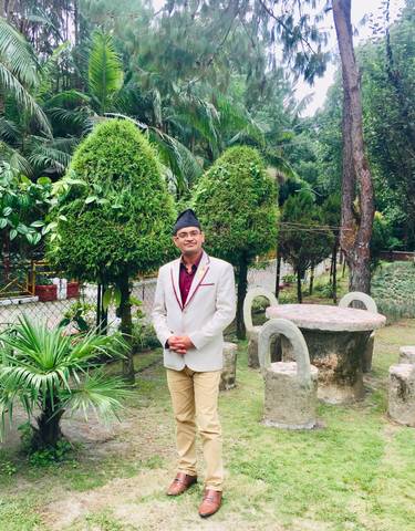Person in a garden area with decorative plants.