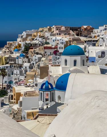 View of Santorini with white buildings and blue domes.