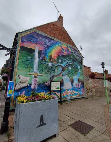 Colorful mural on a building depicting a fantasy scene with nature elements.