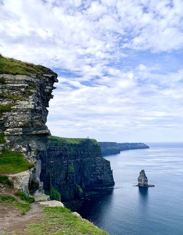 Cliffs overlooking the ocean under a clear blue sky.