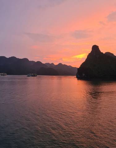 Boats sailing in Halong Bay during sunset