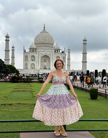 A woman posing in front of the Taj Mahal.