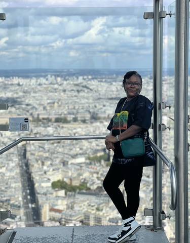 A person standing at a viewing point overlooking Paris.