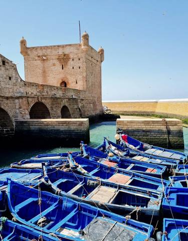 Boats moored in front of a historic fortress.