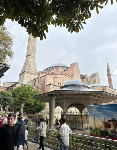 Hagia Sophia with its domes and minarets under a cloudy sky.