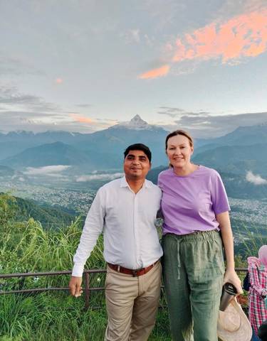 Two people posing with mountains in the background.