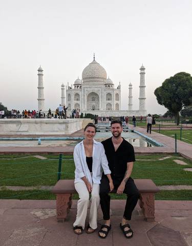 A couple posing in front of the Taj Mahal.