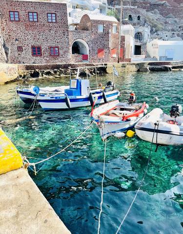 Small boats docked in clear blue water.