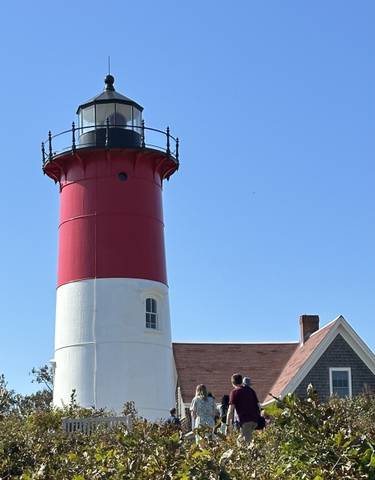 Lighthouse with red and white stripes against a clear sky.