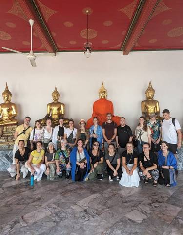 Group of people posing with Buddha statues.