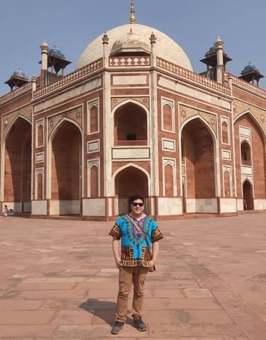 Man posing in front of a historic building in New Delhi.