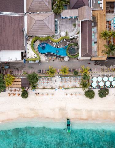 Aerial view of a beach with lounge chairs and a pool.