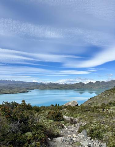 Expansive blue lake with mountains in the distance.