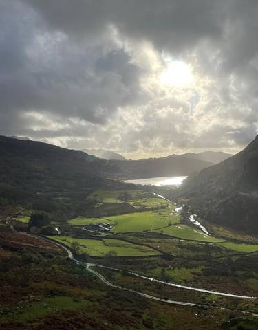 Scenic valley view with a river reflecting sunlight.