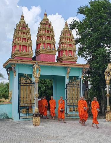 Monks walking through a temple gate in vibrant robes.