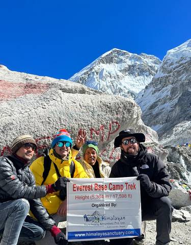 Group of hikers posing in front of a snowy mountain.