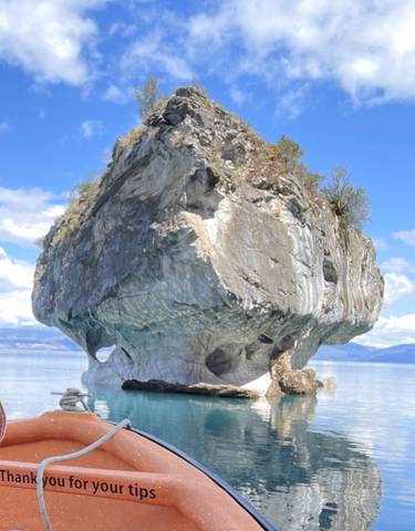 A large, uniquely shaped rock formation in water.