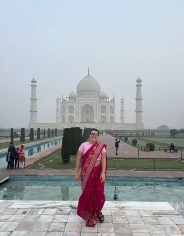 A woman in traditional dress in front of the Taj Mahal in Agra, India.