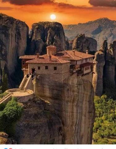 Monastery on a dramatic rocky landscape, with sunlight casting vibrant shadows.