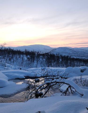 Snow-covered landscape with sunset.