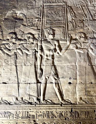 Egyptian wall carvings showing figures in profile.