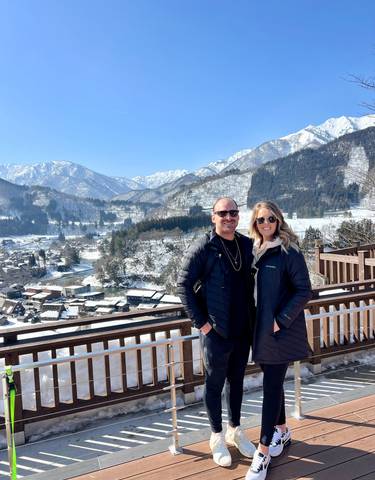 Couple posing with snow-covered mountains.