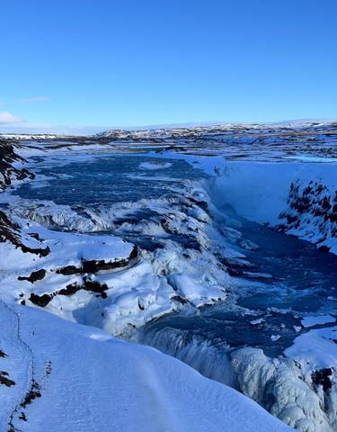 Frozen waterfall and icy river landscape.