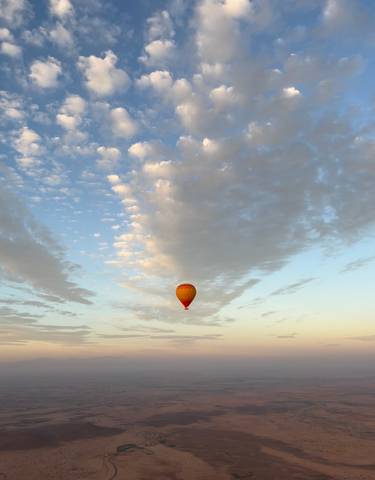 Hot air balloon in a sky filled with clouds.