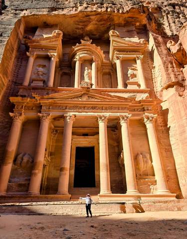 The Petra Treasury lit by sunlight under a clear sky