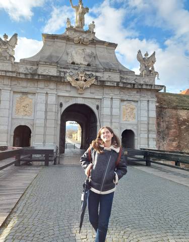 Person standing in front of a decorative archway entrance.