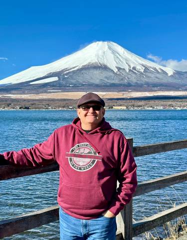 Person posing with Mount Fuji in the background.