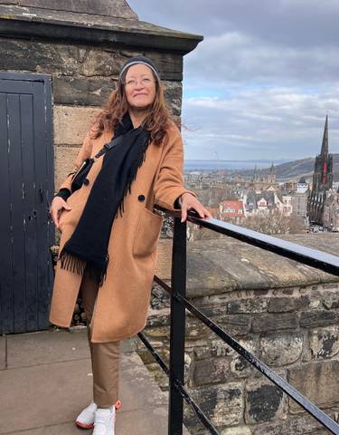 Woman posing with cityscape in the background.