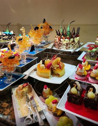 Display of various colorful desserts and pastries.