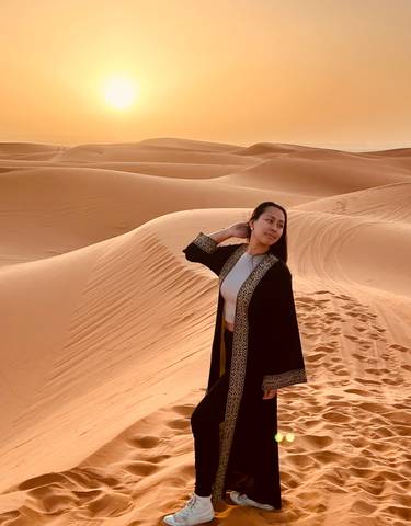 Person posing in Moroccan desert sand dunes.