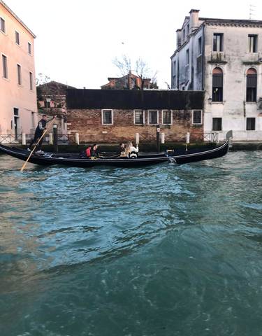 Gondola ride with tourists in Venice's canal.
