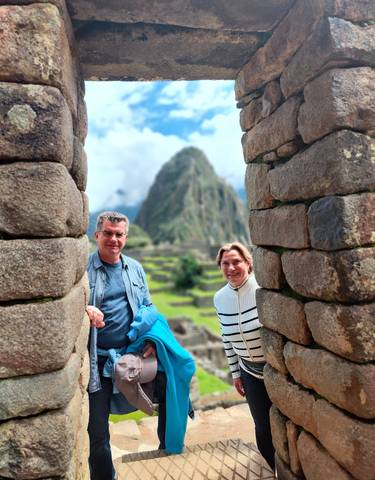 Two people framed by stone structures at Machu Picchu.