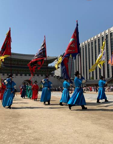 Traditional ceremony with procession of people in colorful attire.