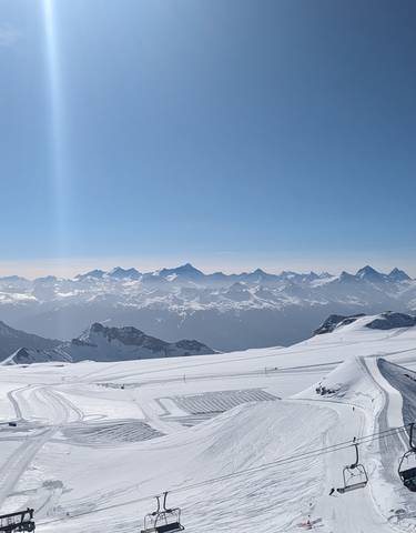 Snowy mountain landscape with clear blue sky.