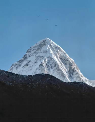 A snow-covered mountain peak under a clear blue sky.