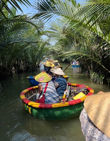 Tourists paddling through a lush green waterway in basket boats.