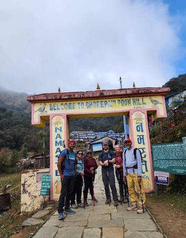 Group of people in front of Ghorepani sign.