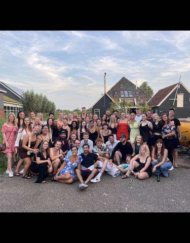 Large group portrait with a scenic, rural background.
