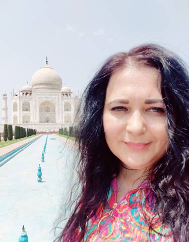 Woman posing in front of the Taj Mahal.