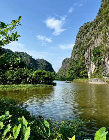 Scenic river winding through lush limestone mountains.
