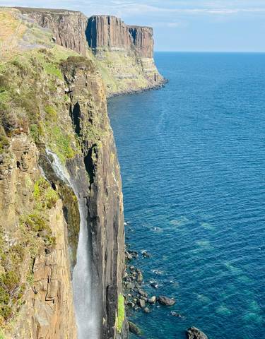 Majestic waterfall cascading down a cliff into the sea.
