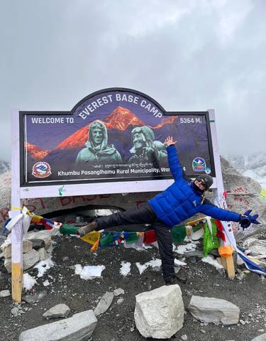 Person posing in front of the Everest Base Camp sign.