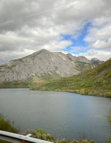 Mountain range with a lake and lush greenery.