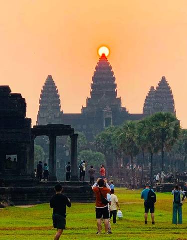 Angkor Wat temple silhouetted against a sunrise or sunset.